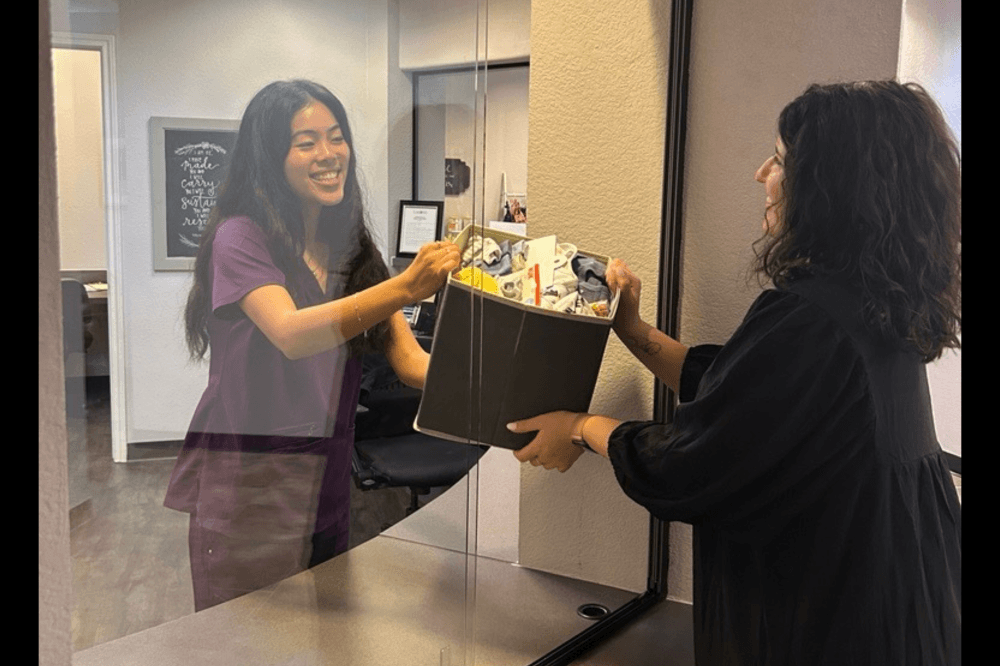 staff member handing client a box of supplies
