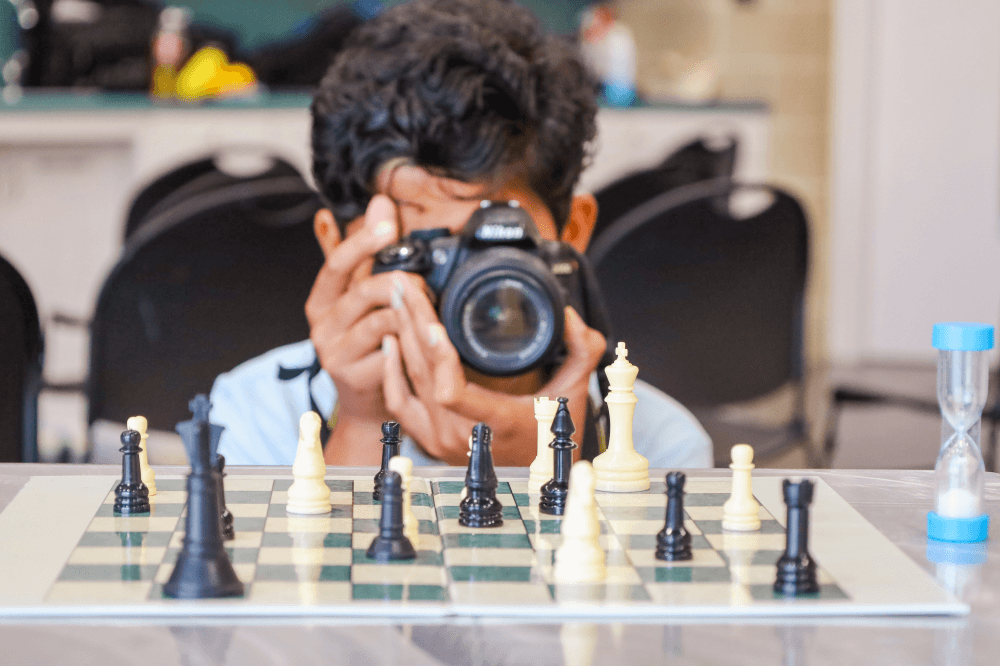 child taking a photo of a chess game