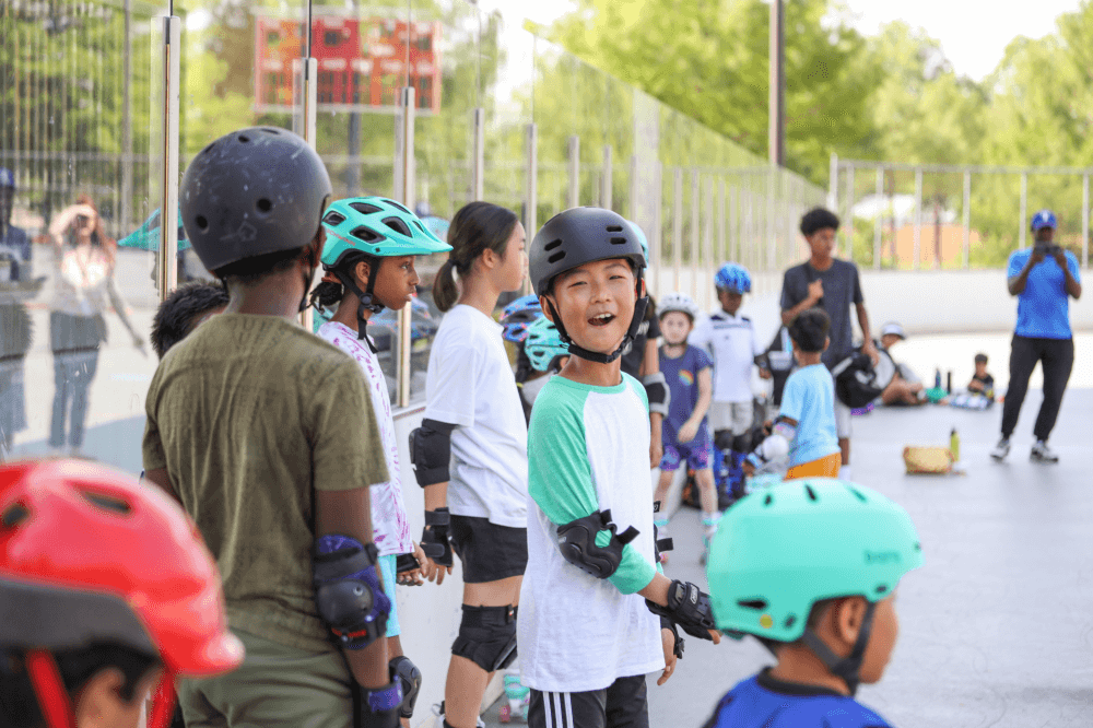 child smiling, getting ready to skateboard