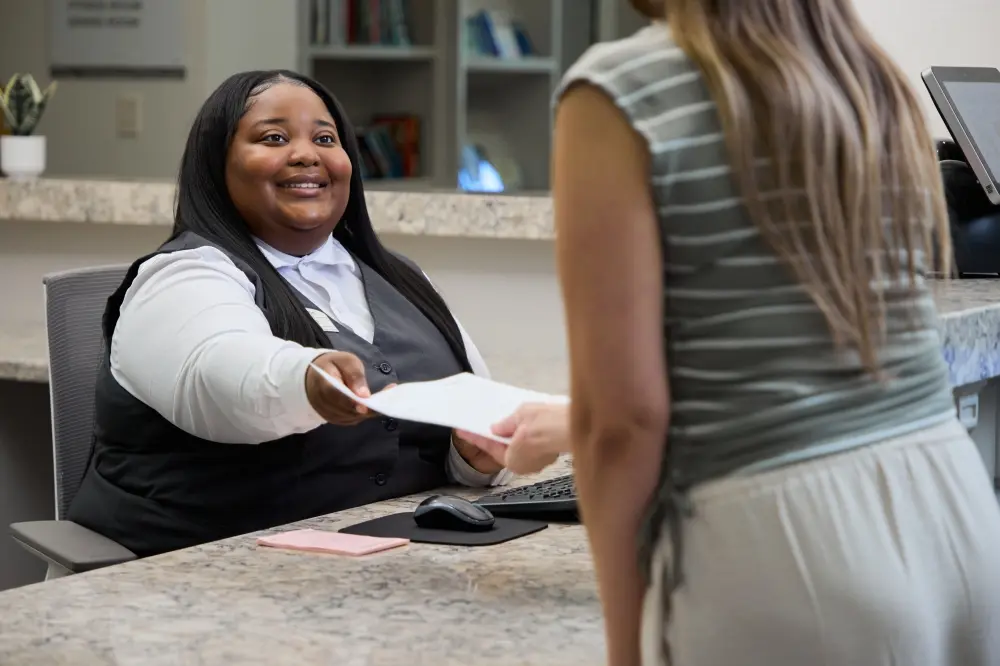 staff member handing a resident papers