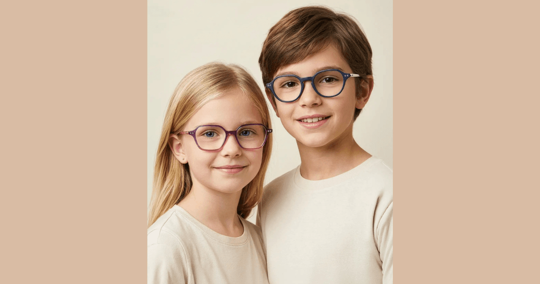 Two children wearing eyeglasses smile at the camera, a girl in purple frames and a boy in blue frames.