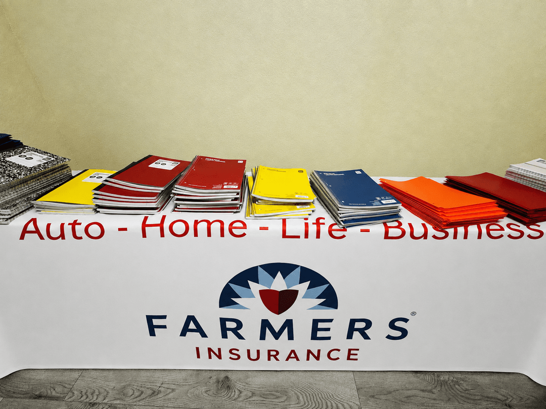 Notebooks and folders on a Farmers Insurance table with "Auto - Home - Life - Business" banner.