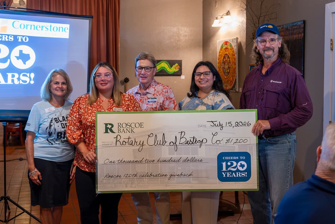 Five people hold a large $1,200 check from Roscoe Bank to the Rotary Club of Bastrop Co. for a 120th celebration giveback.
