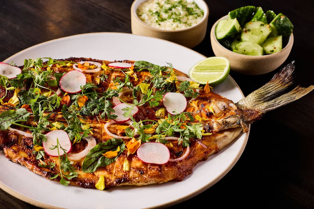 Photo shows a fish filled with greens and vegetables.