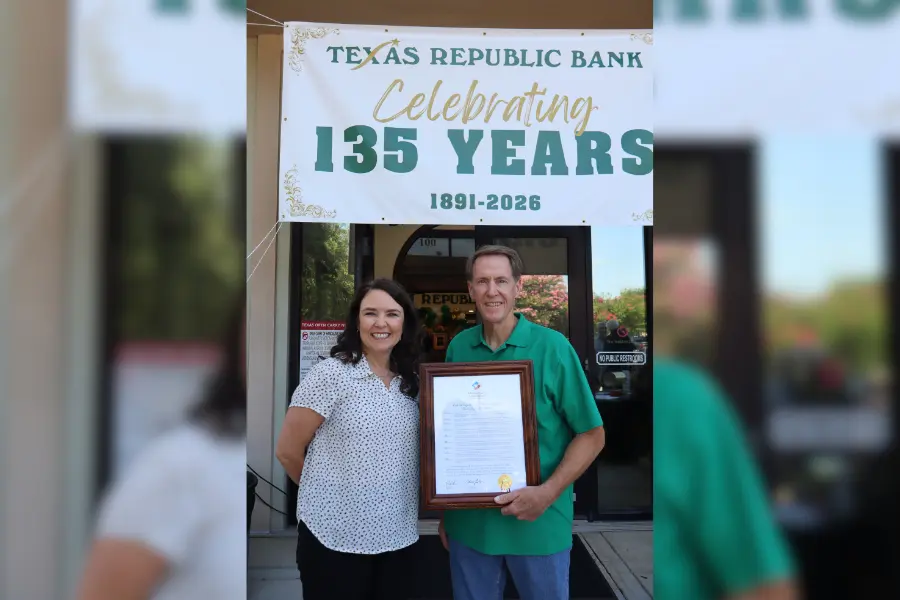 Two people hold a framed certificate beneath a banner reading Texas Republic Bank Celebrating 135 Years 1891-2026.