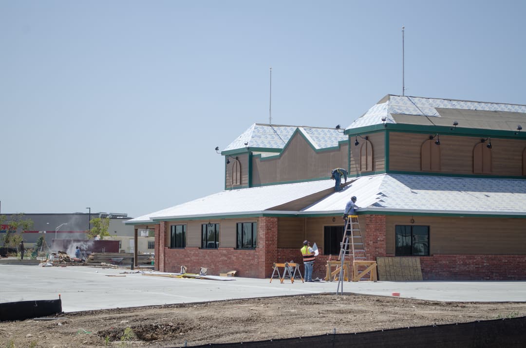 the exterior of a building with workers doing construction