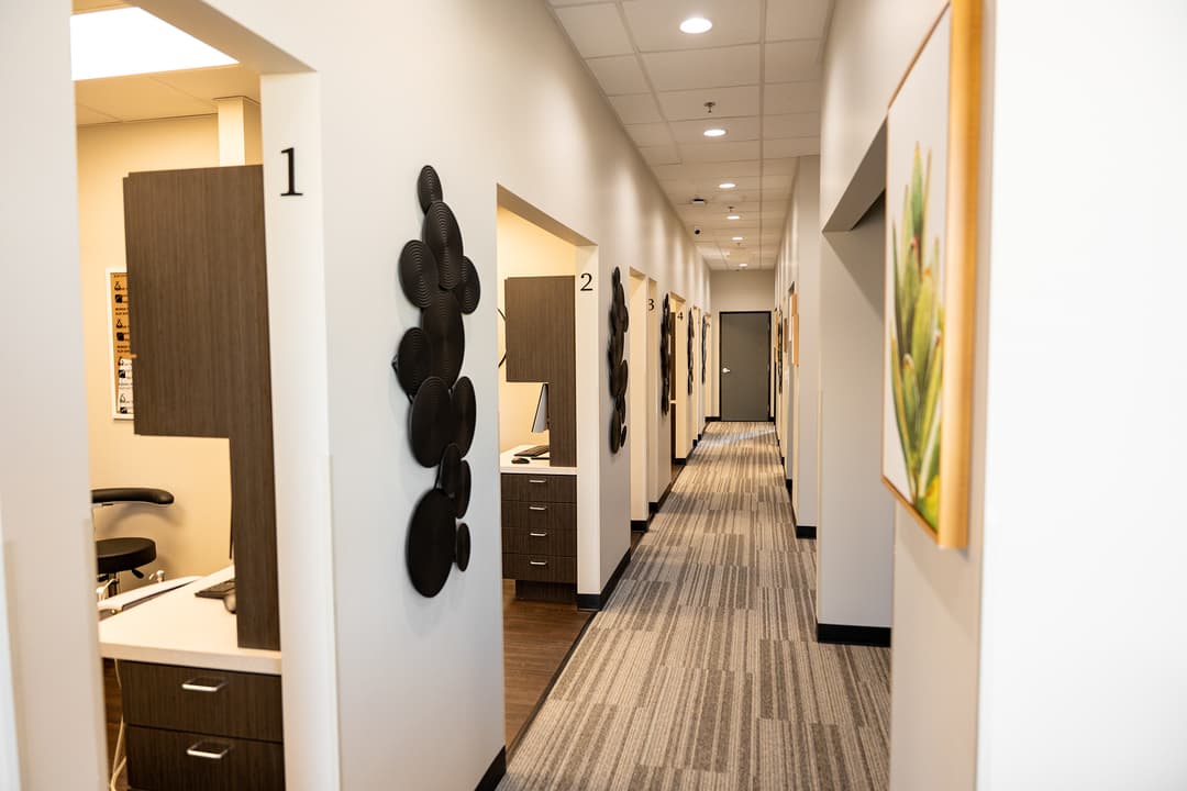 A carpeted hallway in a dentists office with multiple rooms