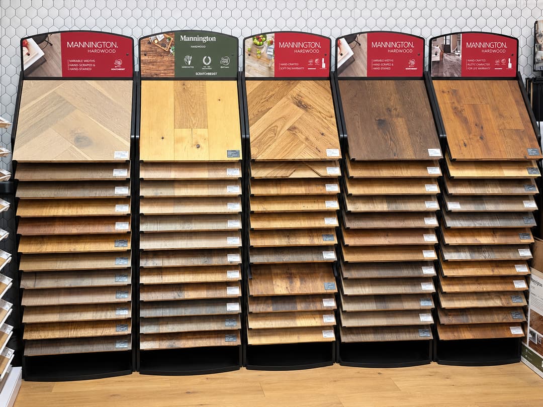 Mannington hardwood flooring sample display with five columns of wood plank options in various stains.