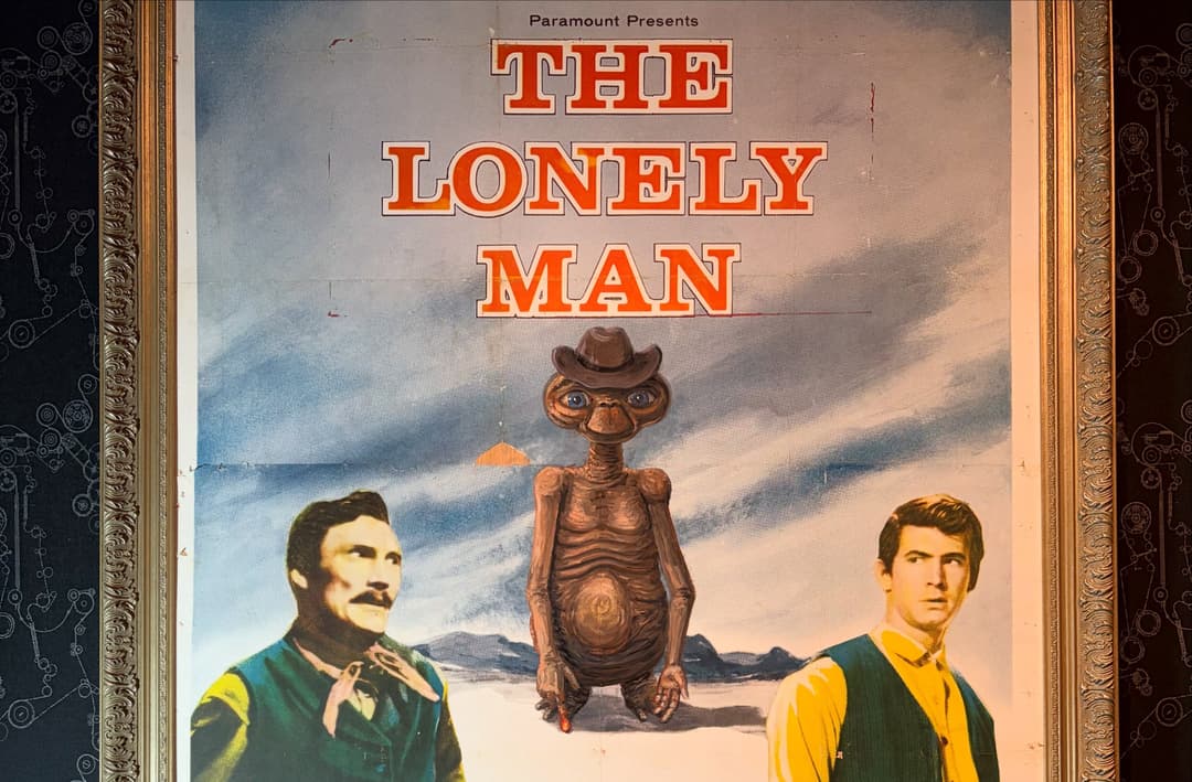 Framed parody poster "The Lonely Man" showing E.T. in a cowboy hat between two Western-era men.
