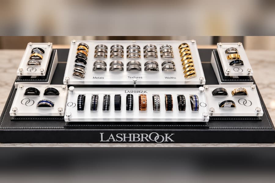 Lashbrook retail display showcasing rows of men's wedding bands in various metals, textures, and widths.