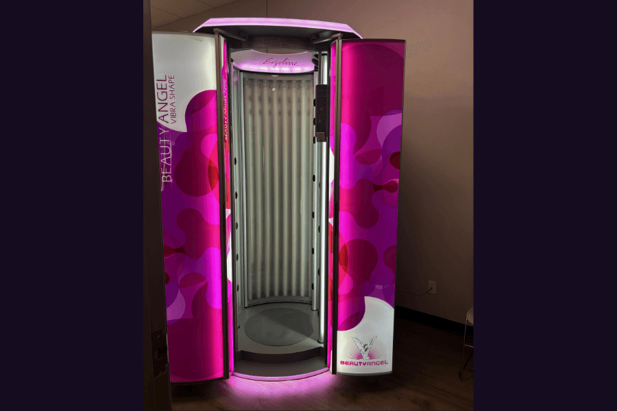 Beauty Angel Vibra Shape red light therapy booth with pink panels and illuminated interior in a salon room.