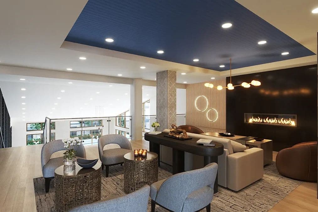 Modern lounge with gray armchairs, linear fireplace, blue recessed ceiling, and floor-to-ceiling windows.