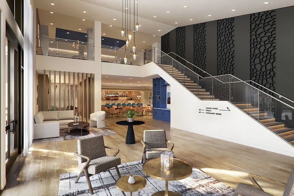 Modern apartment lobby with lounge seating, staircase, patterned accent wall, and signage for leasing office and amenities.