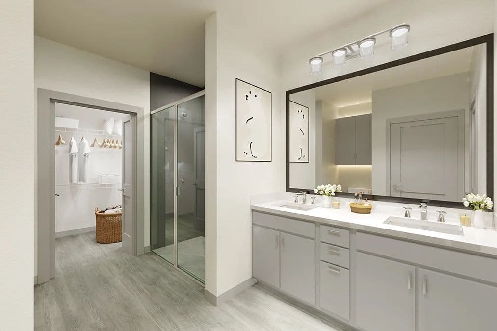 Modern bathroom with double-sink vanity, large mirror, glass shower, and adjoining walk-in closet with white floors.
