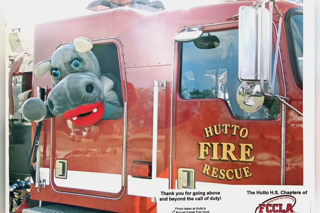 Hippo mascot leaning out the window of a red Hutto Fire Rescue truck, with an FCCLA thank-you message.