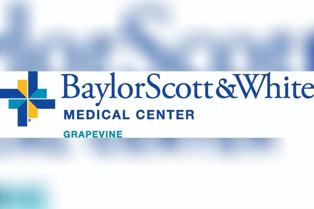 Baylor Scott & White Medical Center Grapevine logo with blue and yellow cross on a blurred background.