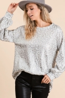 blonde woman in grey sweater, black leather pants and grey hat