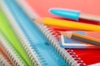 pencils and pens resting on a stack of spiral notebooks fotolia stock image