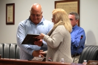 Former Council Member John Bickford receives a plaque from Mayor Sara Countryman in recognition of his service to the city. (Andy Li/Community Impact Newspaper)