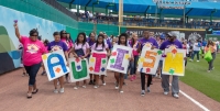 Montgomery's three daughters (center), who are all diagnosed with autism spectrum disorder, walk in the annual Family Strike Out Parade. (Courtesy Hope Collins Montgomery)