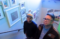 As diners come up the stairs to Be More Pacific, they pass the family photos of owners Giovan Cuchapin (left) and Mark Pascual. (Jack Flagler/Community Impact Newspaper)