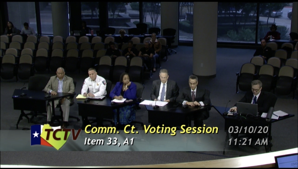 A photo of Travis County officials presenting to the commissioners court.