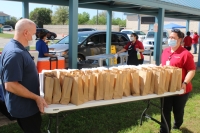 Leander ISD child nutrition services employees carry out a table of lunches at Bagdad Elementary School in Leander on March 25. (Brian Perdue/Community Impact Newspaper)