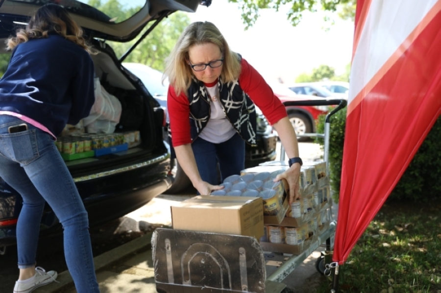 Mimi Conner (right) unloads food from her car after picking up non-perishable foods from the North Texas Food Bank and purchasing foods from Aldi, with help from volunteer Michelle Leavitt. (Liesbeth Powers/Community Impact Newspaper)