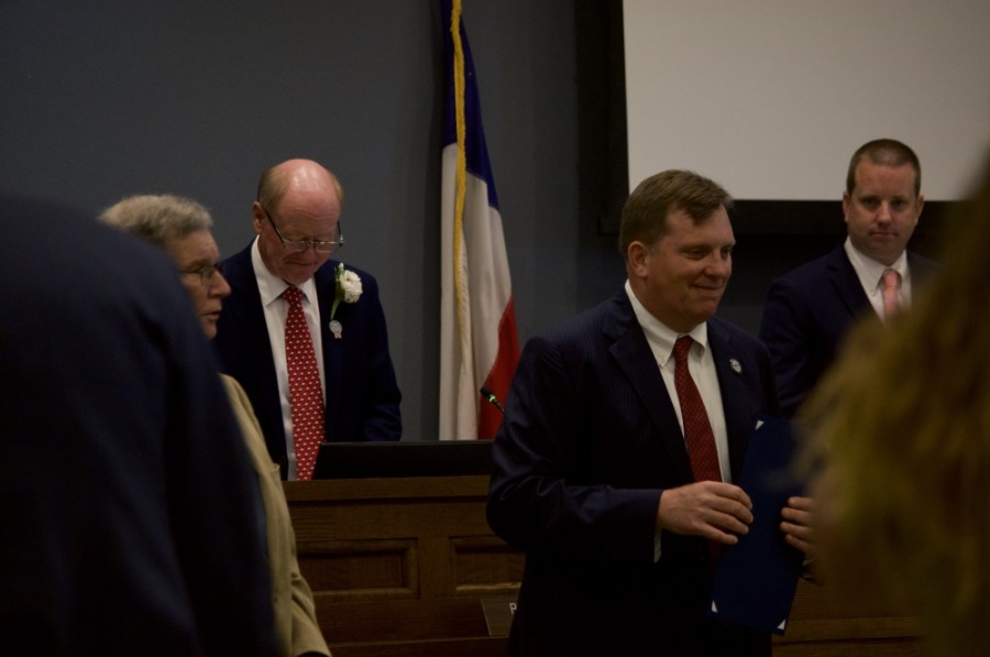 Former Mayor Barron Casteel (foreground right) stands in front of the dais and Mayor Rusty Brockman (background left) at Tuesday's City Council meeting, May 26, 2020.(Warren Brown/Community Impact Newspaper)