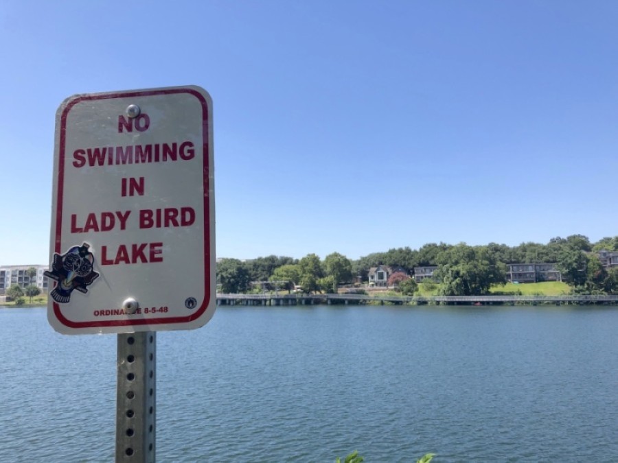 A sign along the Ann and Roy Butler Hike and Bike trail reminds residents not to swim in Lady Bird Lake. (Jack Flagler/Community Impact Newspaper)
