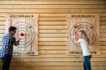A man and a woman laughing with target boards