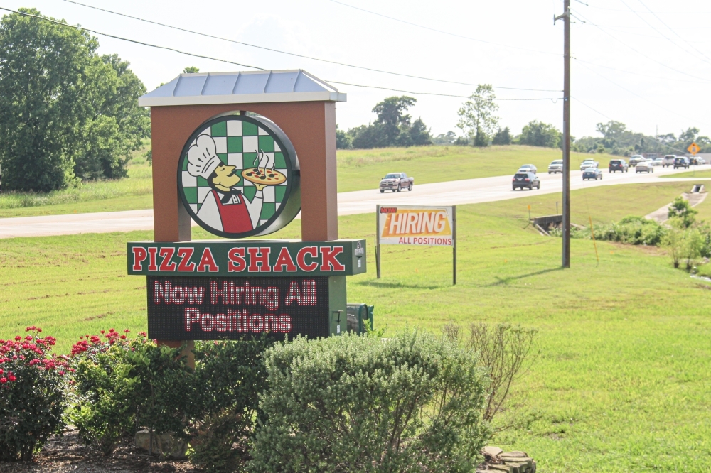 Many restaurants along Hwy. 105 in Montgomery, such as Pizza Shack, have “now hiring” signs displayed. (Eva Vigh/Community Impact Newspaper)