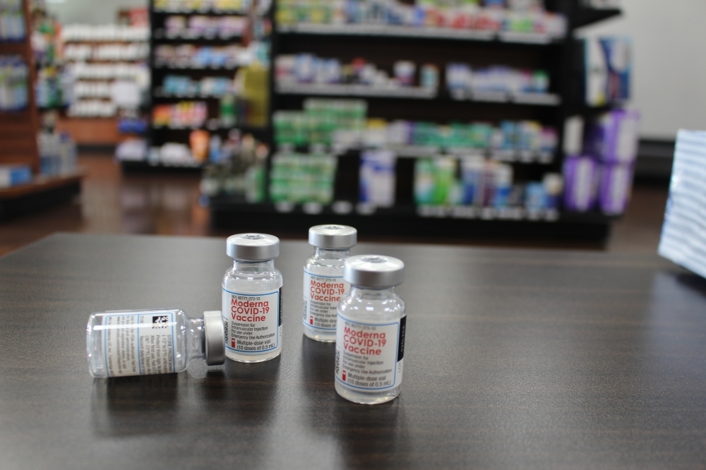 Photo of four vaccine vials in a pharmacy