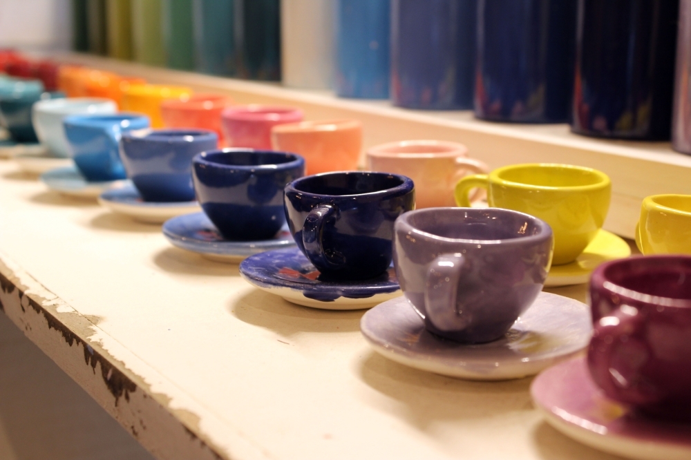A colorful display of painted teacups indicate the paint color after pottery pieces are fired. (Karen Chaney/Community Impact Newspaper)