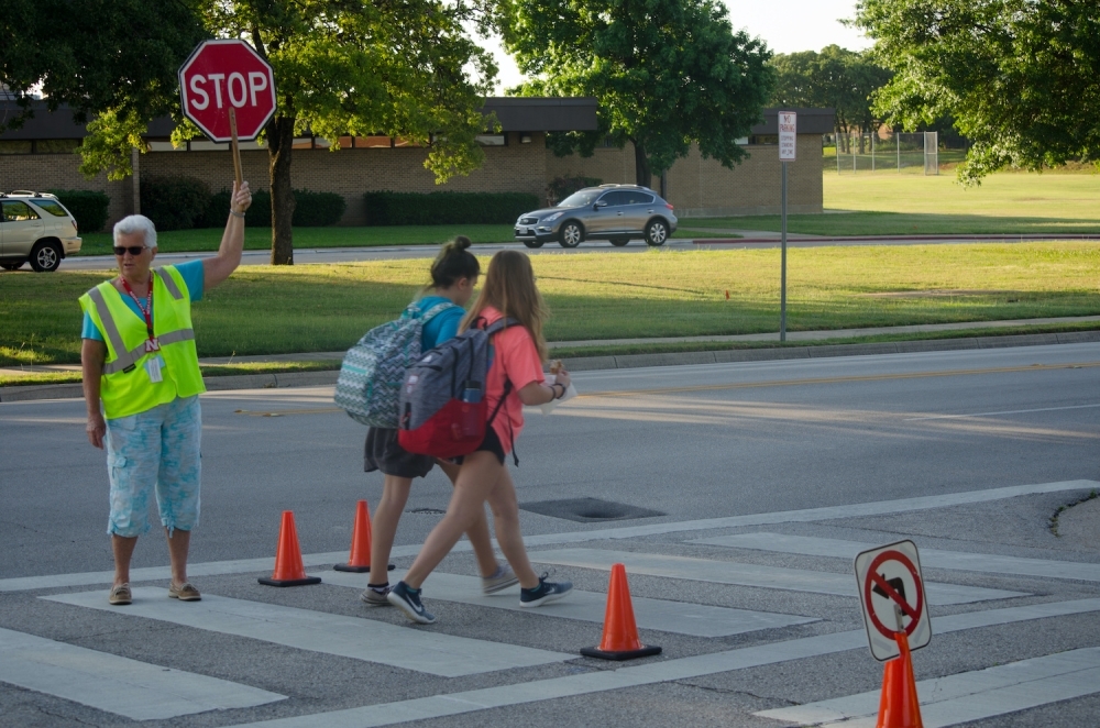 School crosswalk with crossing guard and two students