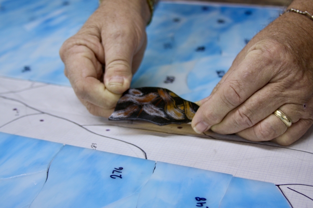 Paint is applied to some pieces of glass to provide more detail in the design. (Lauren Canterberry/Community Impact Newspaper)