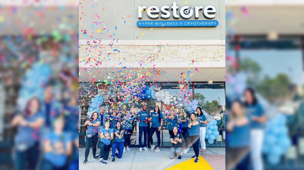People celebrate a store opening with confetti.