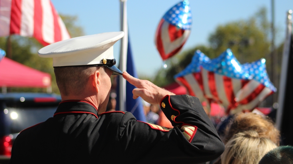 A marine attendee salutes veterans in the parade. (Sandra Sadek/Community Impact Newspaper)