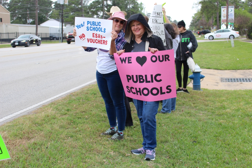 Public school advocates protest Abbott's school choice message across the street from Cypress Christian School. (Danica Lloyd/Community Impact)