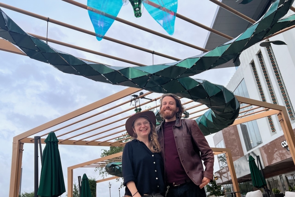 Partners and co-creators of 'Efflorescence,' the Austin-based artist team consisting of Ilya Pieper and Nathan Kandus from Whiptail Designs, stand next to their art installation at the Ion on March 30. (Melissa Enaje/Community Impact)