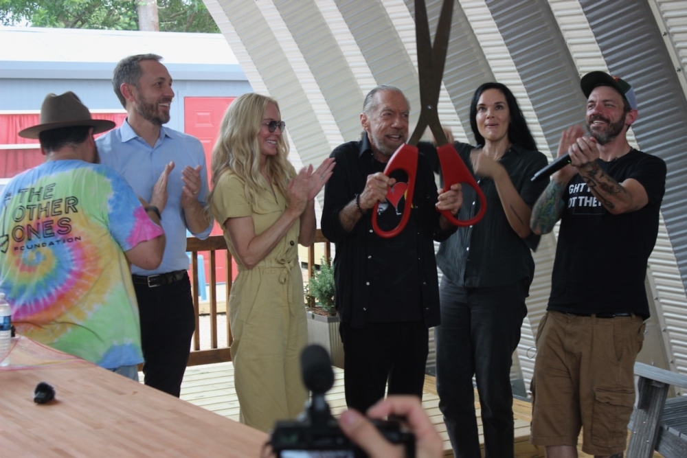The first 50-cabin neighborhood in the Esperanza Community is named after Peace, Love & Happiness Foundation founder John Paul DeJoria, center. (Ben Thompson/Community Impact)