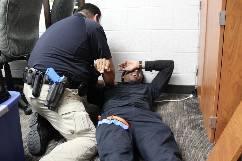 Once the suspect is neutralized, law enforcement officers begin applying tourniquets on victims who have been injured. (Danica Lloyd/Community Impact)