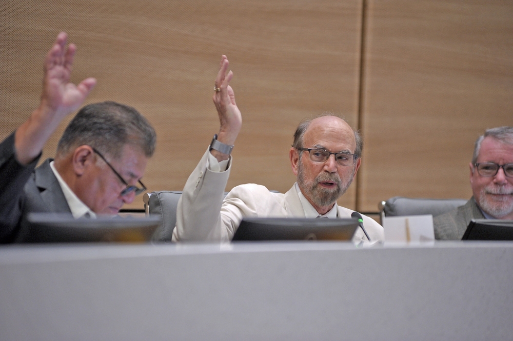 Tom Jackson (center) votes on agenda items at a Sept. 11 board meeting. (Tony Bullard/Community Impact)