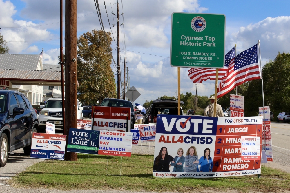 Campaign signs line the street outside Juergen's Hall Community Center in Cypress on Election Day. (Danica Lloyd/Community Impact)