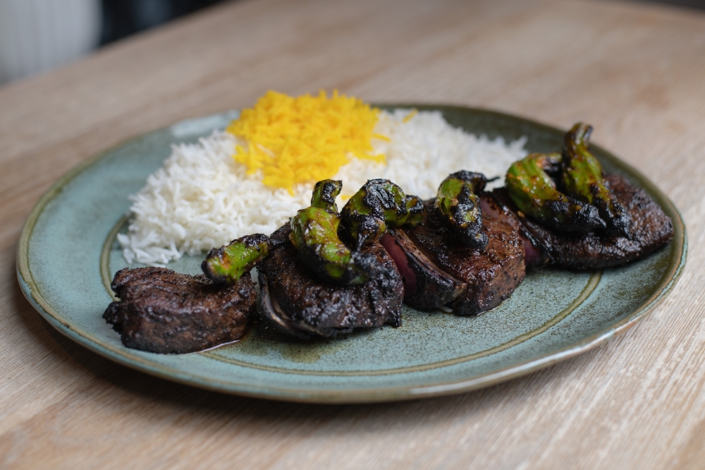 The American Wagyu Zabuton kabob is one of the menu items served at Rumi's Kitchen. It is served with an urfa chili spice rub and grilled shishito peppers. (Courtesy Rumi’s Kitchen & Alex Montoya)