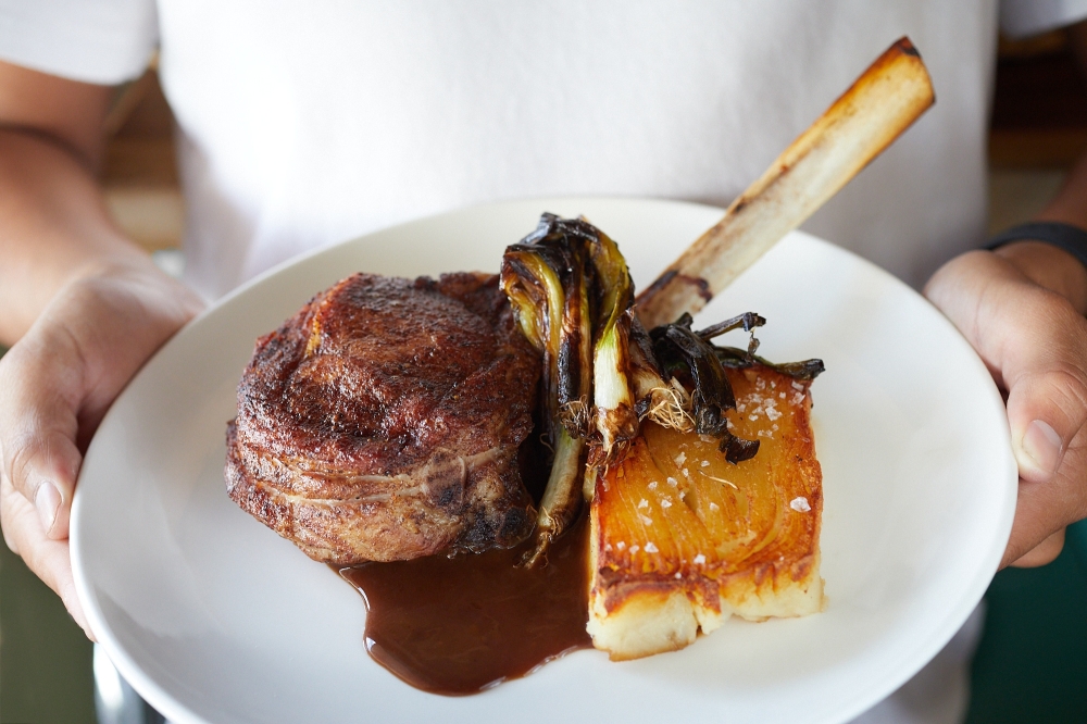 The porcini-rubbed veal chop at Gina's On Congress is served with charred scallion and potato au gratin. (Courtesy Jody Horton)