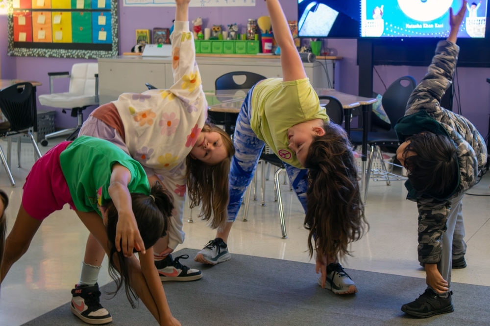 Cowan Elementary students practice yoga in their classroom to prepare for the day. (Elle Bent/Community Impact)