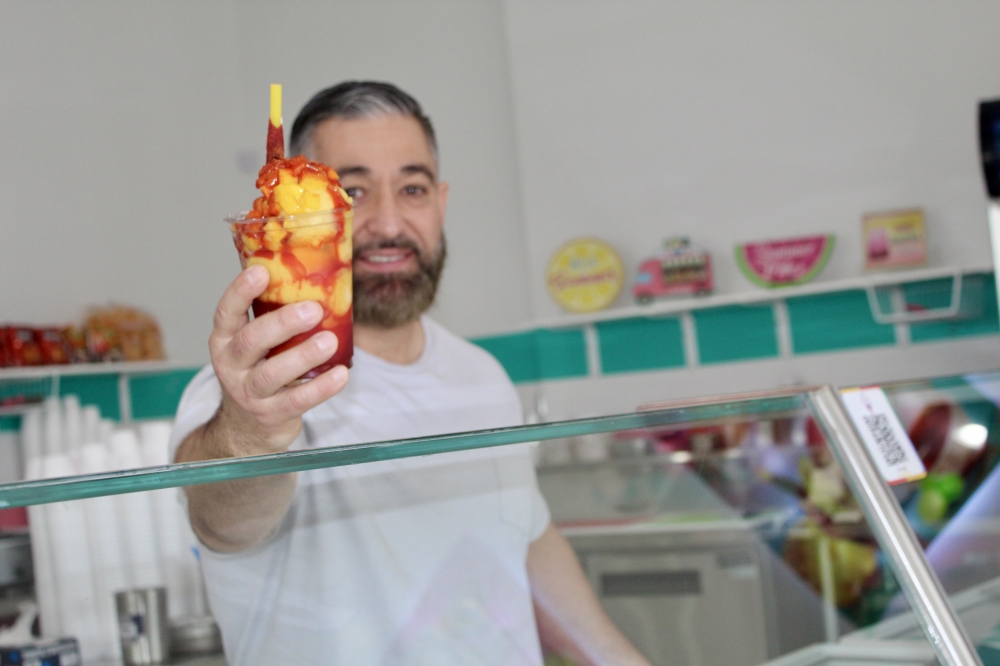 Co-owner Jorge Padilla serves a mangonada. (Jovanna Aguilar/Community Impact)