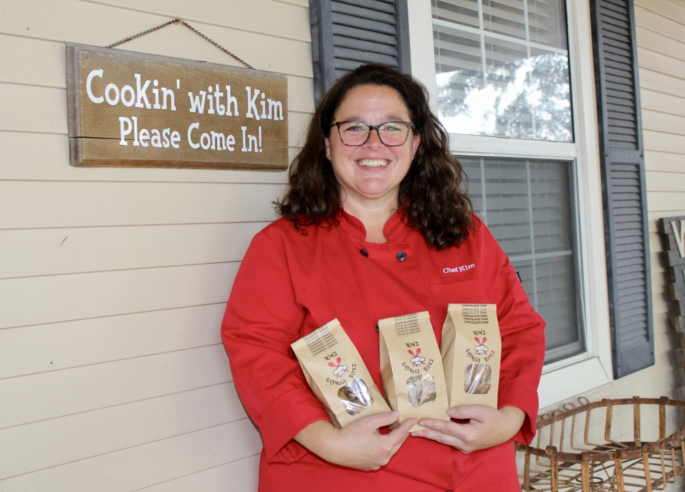 Kim Liberta holds Kim’s Granola Bites in front of her establishment. (Jovanna Aguilar/Community Impact)