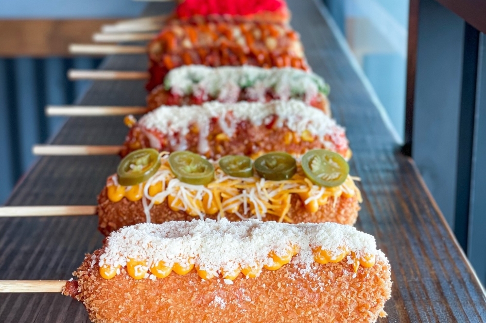 The fried savory sticks have five options for fillings, including traditional sausage or cheese, as well as numerous toppings, such as potato, elote or crushed spicy Cheetos. (Courtesy Krazy Dog)